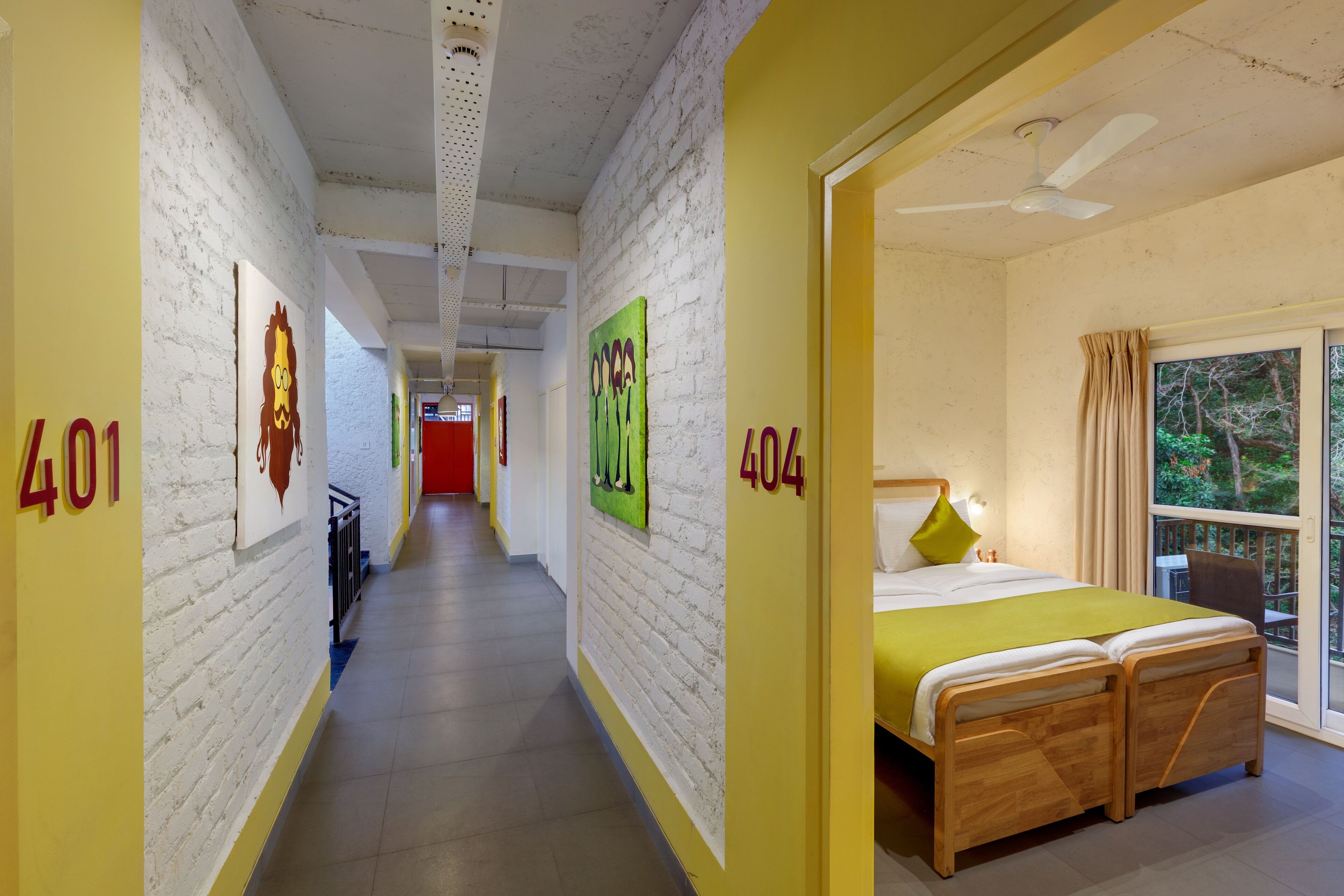A hotel corridor with numbered rooms, a wooden bed, and a window with a view.