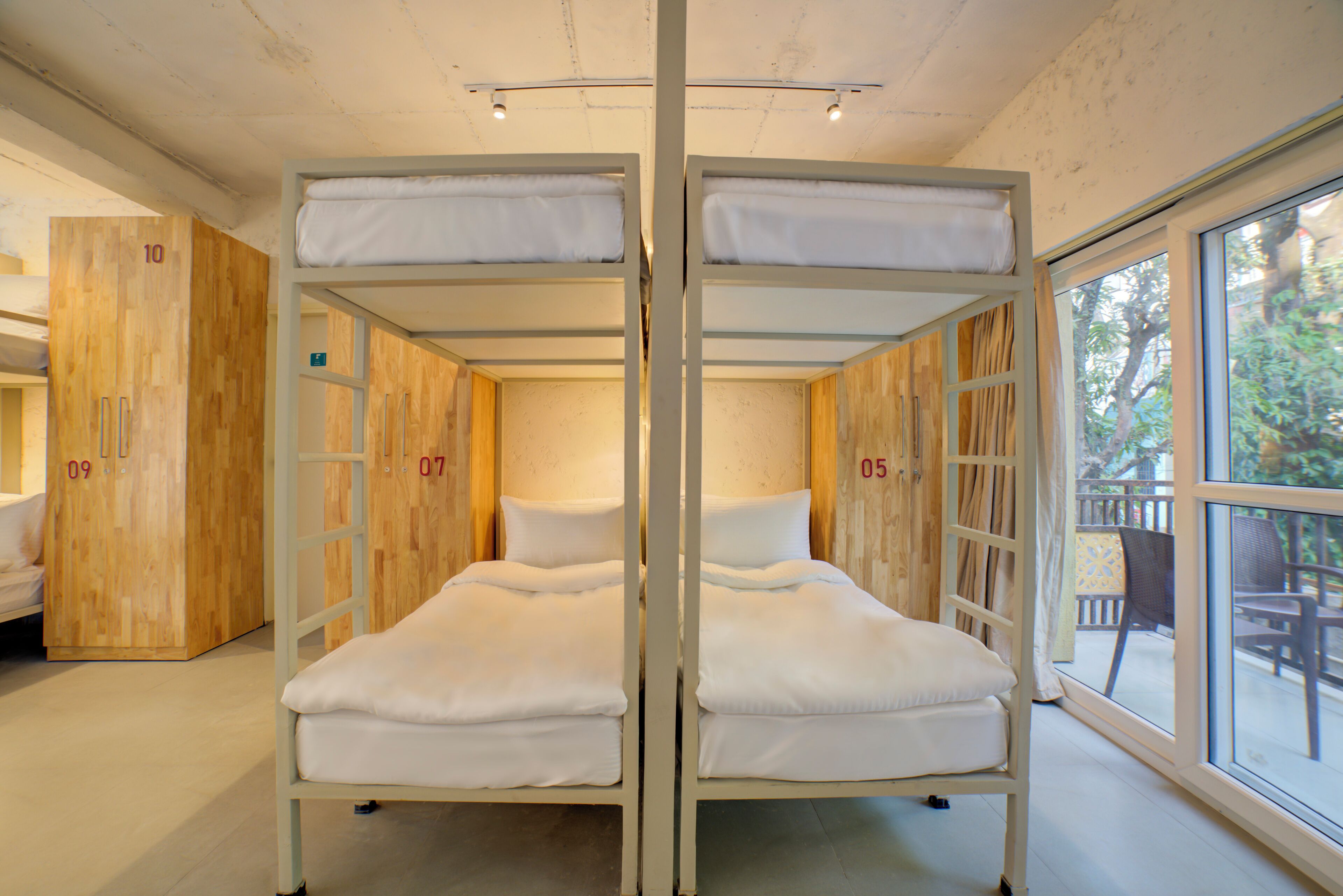 A room with bunk beds, wooden walls, and a large window.