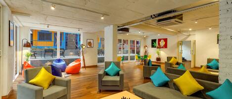 A spacious lounge area with multiple seating options, including sofas and armchairs, and a chess table in the center.