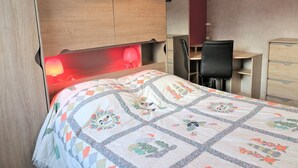 A bedroom with a bed, a desk, a chair, and a wardrobe. - Apartment with terrace, WIFI and parking in Perros-Guirec (Perros-Guirec)