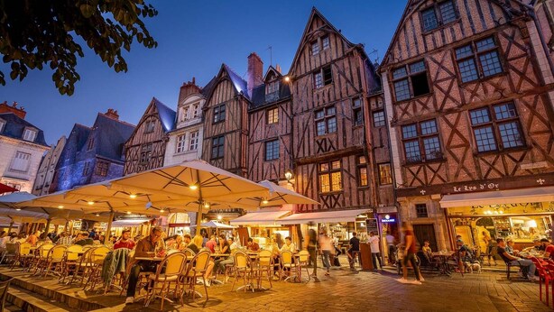A historic European street with traditional timber-framed buildings, outdoor seating areas, and a bustling atmosphere. - A dream holiday in the heart of nature in a historic setting (Beaumont-Louestault)