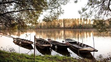 Un lago tranquillo con tre barche di legno ormeggiate a un molo.