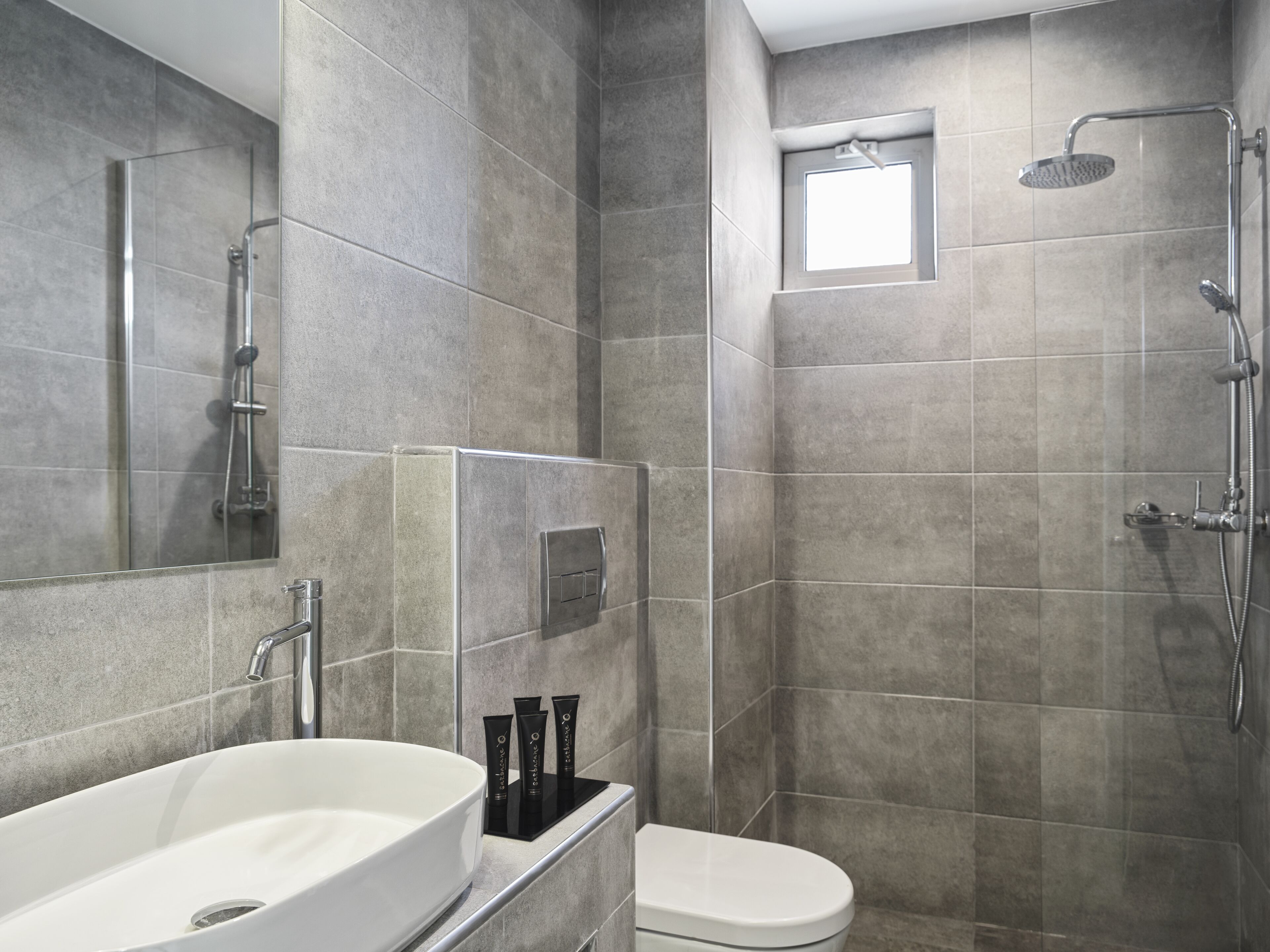 A modern bathroom with a large bathtub, a toilet, and a shower area.