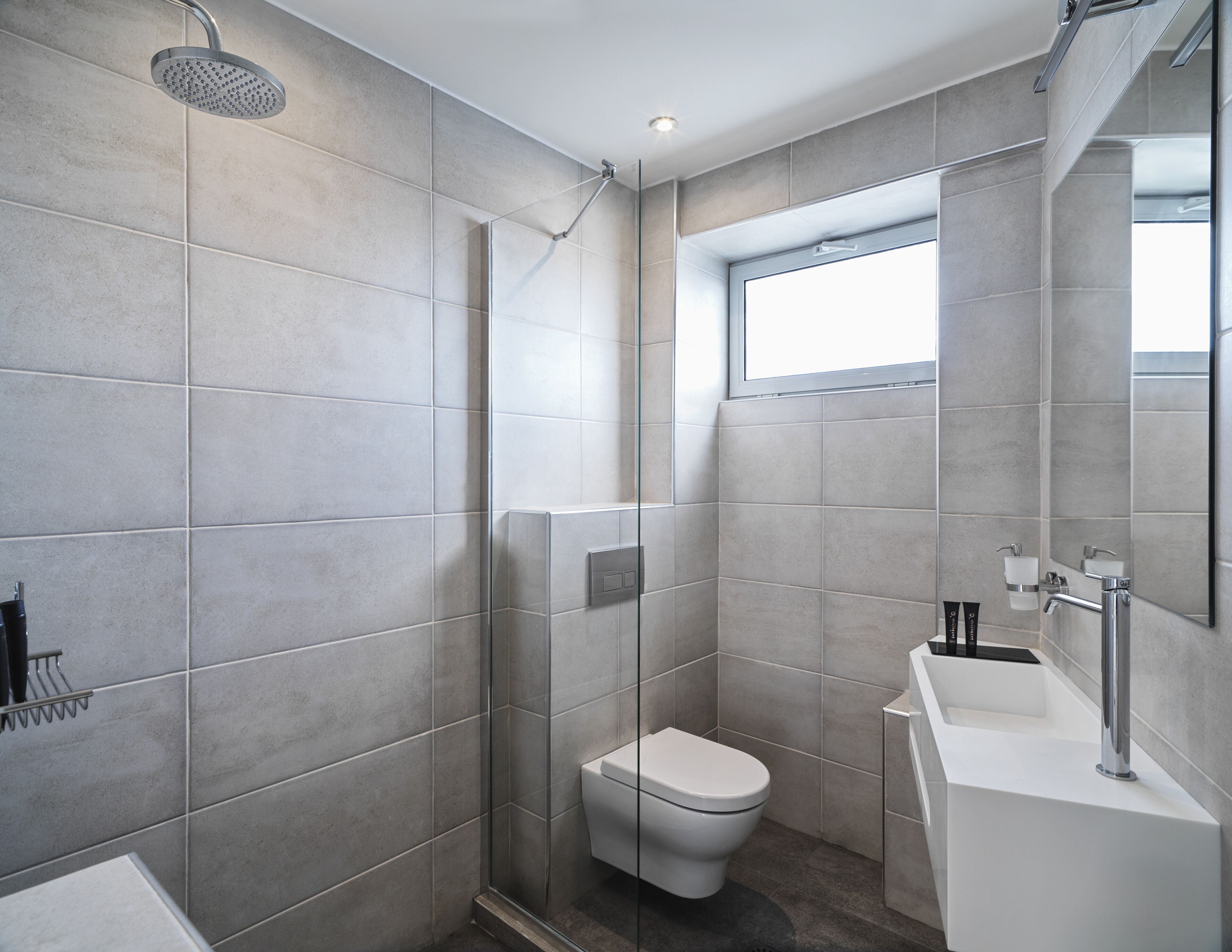Un baño moderno con ducha, inodoro y lavamanos.