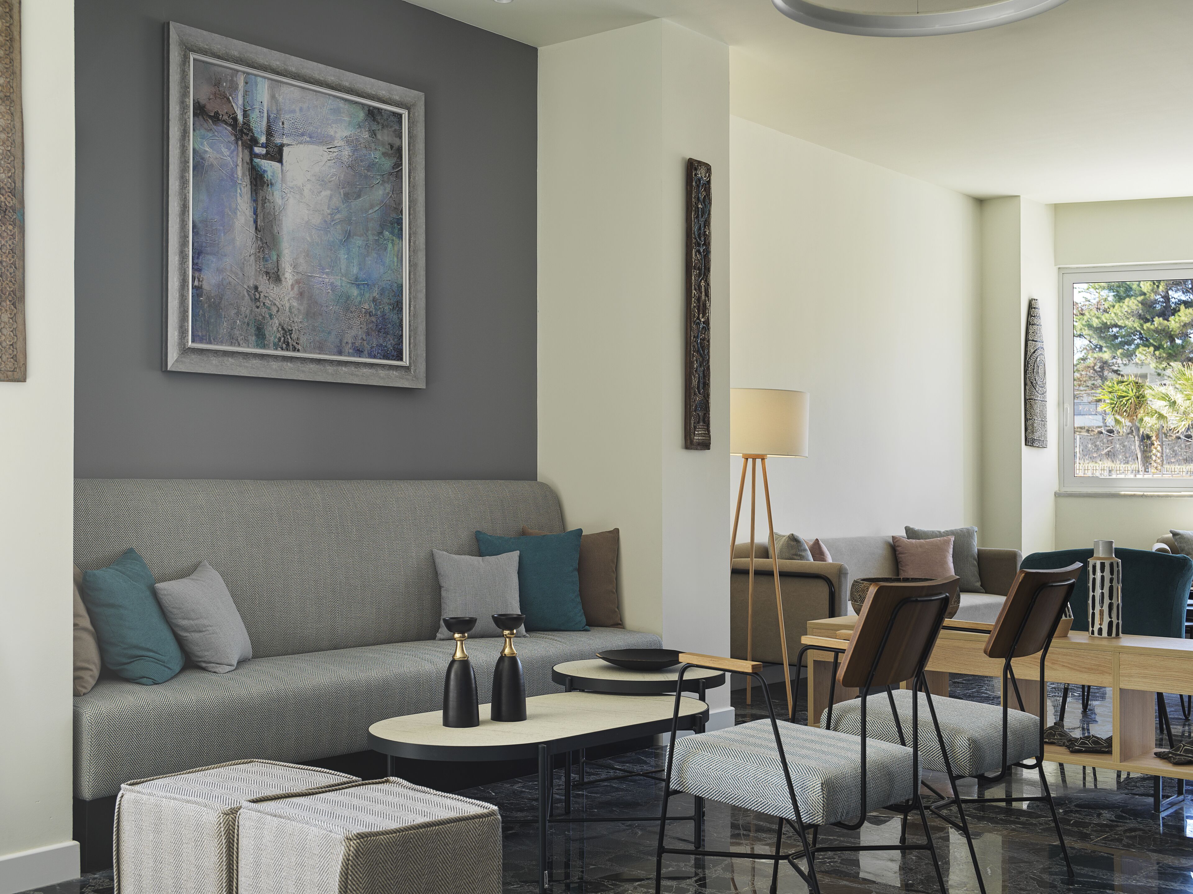 Una sala de estar moderna con un sofá gris, una mesa de centro y una lámpara de pie.