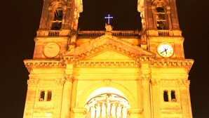 A large, illuminated church with two towers and a central archway.