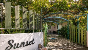 Un chemin menant à un bâtiment sur lequel est affiché un panneau indiquant « Sunset ».