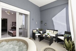 A modern living room with a glass door leading to a bedroom, a black wicker sofa set, a coffee table, and a large potted plant.