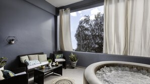Un balcon équipé d’un canapé, de chaises, d’une table et d’un jacuzzi.
