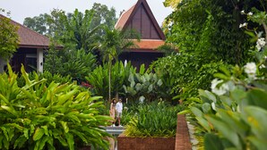 A tropical resort with a pool surrounded by lush greenery and a traditional-style building with a red roof. - Angkor Green Gardens by Dara (Siem Reap)