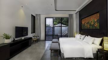 Ein modernes Hotelzimmer mit einem großen Bett, einem Fernseher, einer Sitzecke und einem Balkon mit Blick.