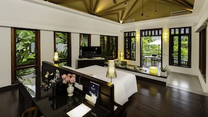A spacious room with a large bed, a desk with a computer, and a television. There are large windows with views of greenery outside. - Angkor Green Gardens by Dara (Siem Reap)