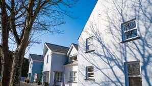 A row of modern, white houses with a clear sky.