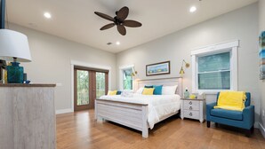 A bedroom with a bed, bedside tables, a ceiling fan, and a window with blinds. - Brand New 3 Bedroom, Pet Friendly Amazing Bay View Home (St George Island)
