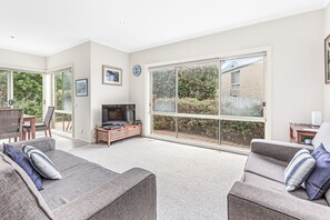 A spacious living room with a large window, a television, and a seating area with two sofas. - Edwards - Family friendly, pet friendly (Apollo Bay)