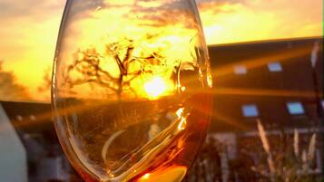 Una copa de vino transparente contra un fondo de atardecer.