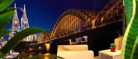 A view of a bridge at night with a cathedral in the background.
