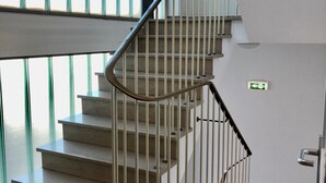 A staircase with metal railings and a handrail, leading to an upper floor. - Montivo Hotel Köln-Bonn Airport (Troisdorf)