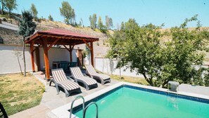 A pool with lounge chairs, a pergola, and a hillside backdrop. - ÇELİK RESORT (Ayas)