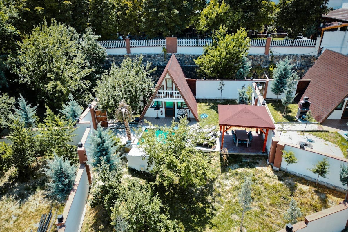 A residential area with a swimming pool, a covered patio, and a fenced garden.