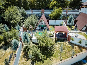 A residential area with a swimming pool, a covered patio, and a fenced garden. - ÇELİK RESORT (Ayas)