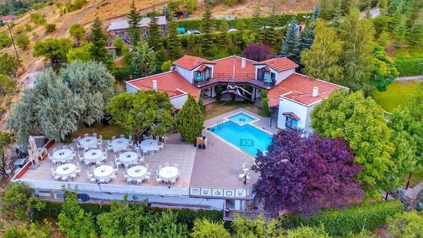 Une grande maison avec une piscine, plusieurs espaces de détente extérieurs et un jardin bien entretenu.
