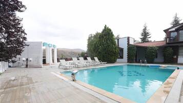 Piscine extérieure, parasols de plage, chaises longues