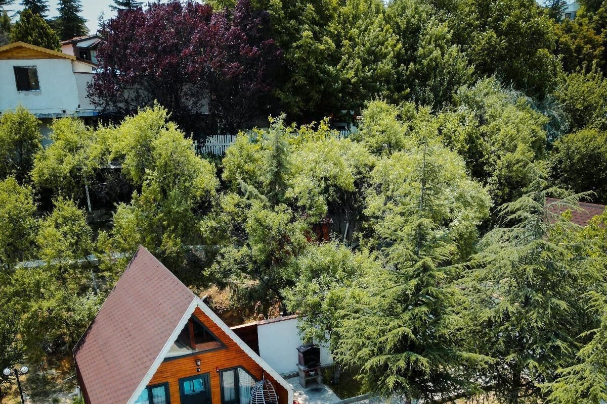 A modern house with a swimming pool, wooden deck, and a fenced yard.