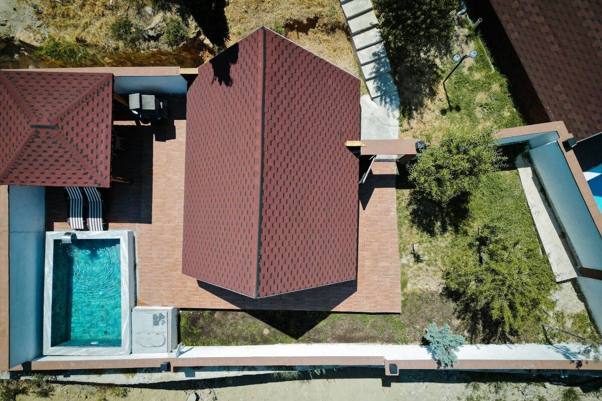 A rooftop pool area with a rectangular pool and a large, flat roof structure.