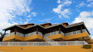 A multi-story building with balconies and a staircase. - Chale Recanto Monte Sinai (Piracaia)