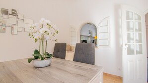 Ein Essbereich mit Holztisch, Stühlen und einer Orchidee im Topf.