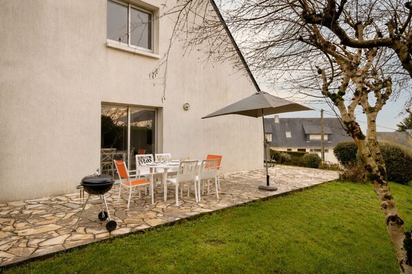 A patio with outdoor furniture, a grill, and a large umbrella. - Sea view house for 6, garden, beach 400 m away (Sarzeau)