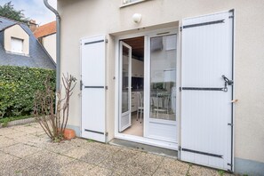 Sliding glass door leads to a covered outdoor area with a garden and gravel driveway.