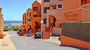 Una hilera de edificios anaranjados con un letrero que dice 'Vasari Village'.