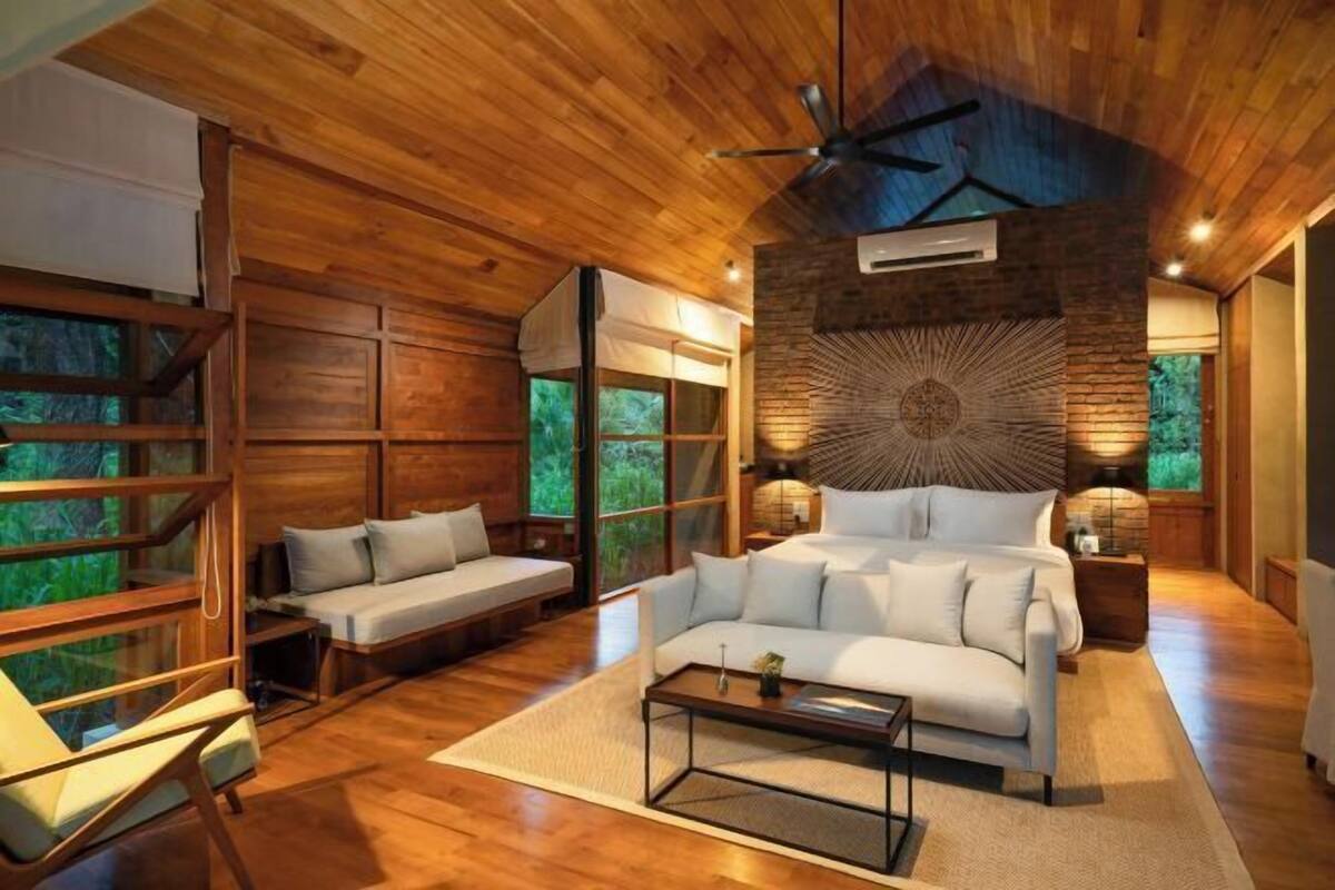 Un intérieur en bois comprenant un lit, un canapé et une table à manger.