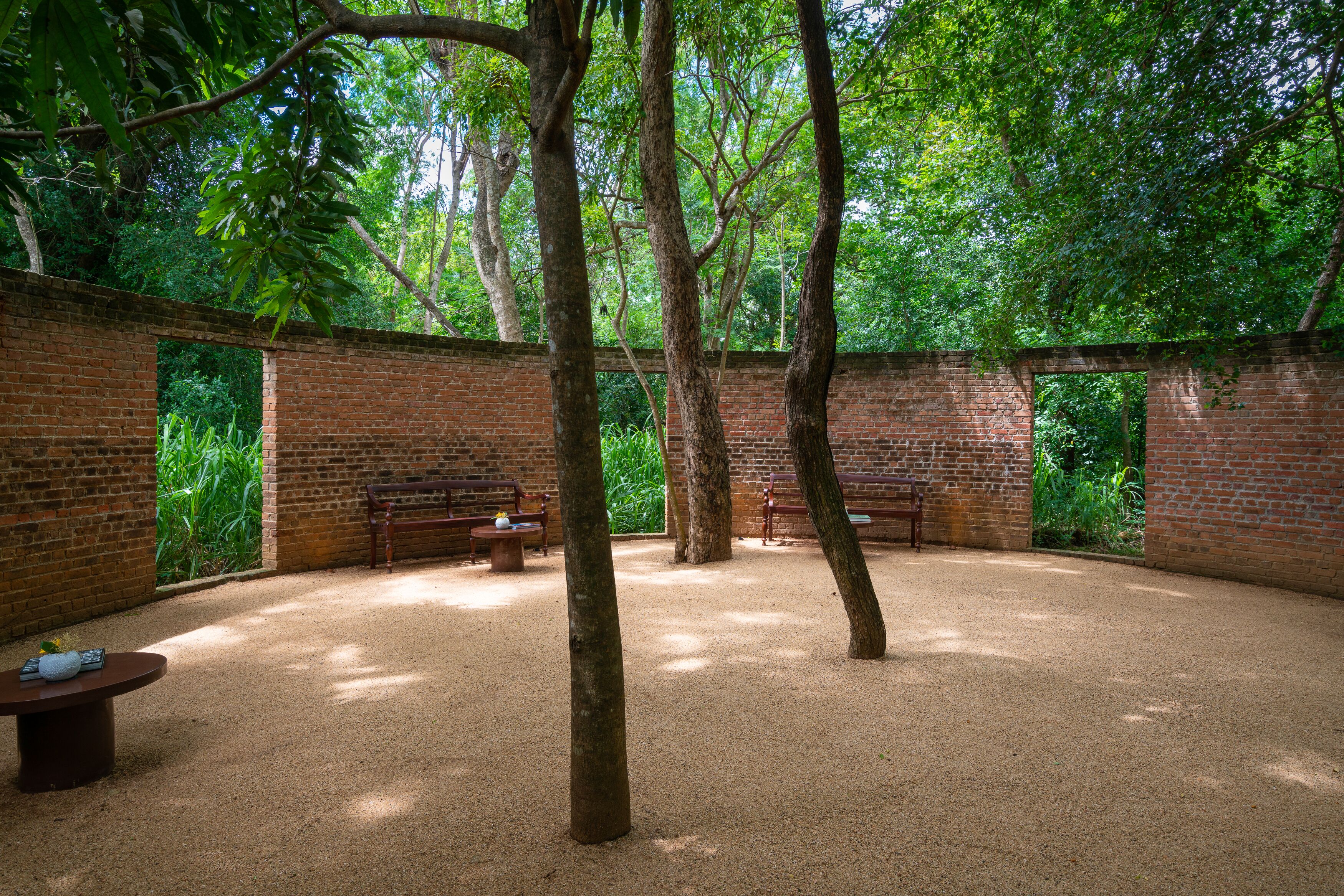 A room with brick walls, a wooden bench, and a table.
