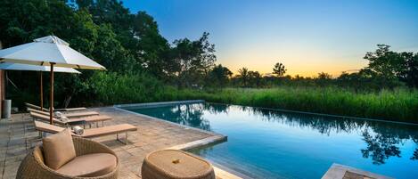 Een buitenzwembad en ligstoelen