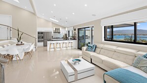 Een moderne woonkamer met een bank, bijzettafeltje en uitzicht op water.
