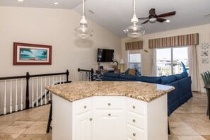 A kitchen with a granite countertop, white cabinets, and a ceiling fan. - Sea-Esta! 4BR Townhome with Community Pool & easy beach access! (Surf City)