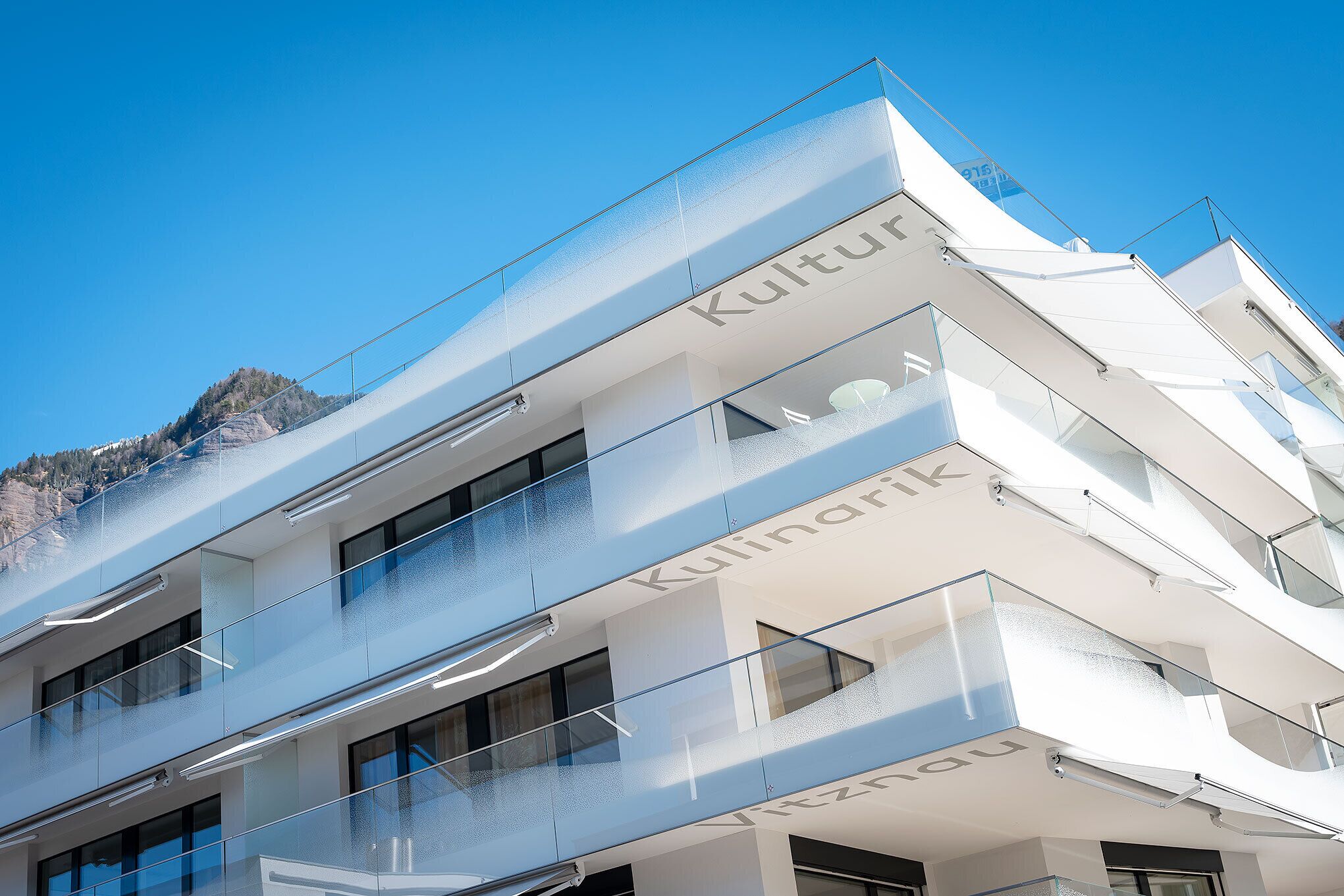 A modern building with balconies and the name "Kulinarik" visible on the facade.