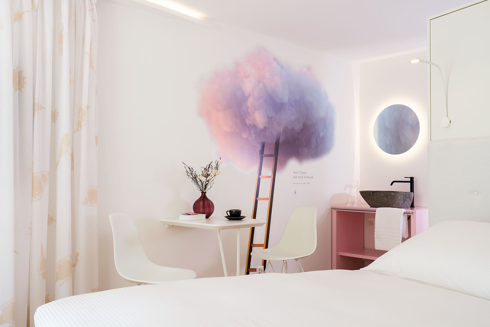 Una camera da letto moderna con un letto, una scrivania con un vaso e una tazza, una scala e un lavandino a parete.