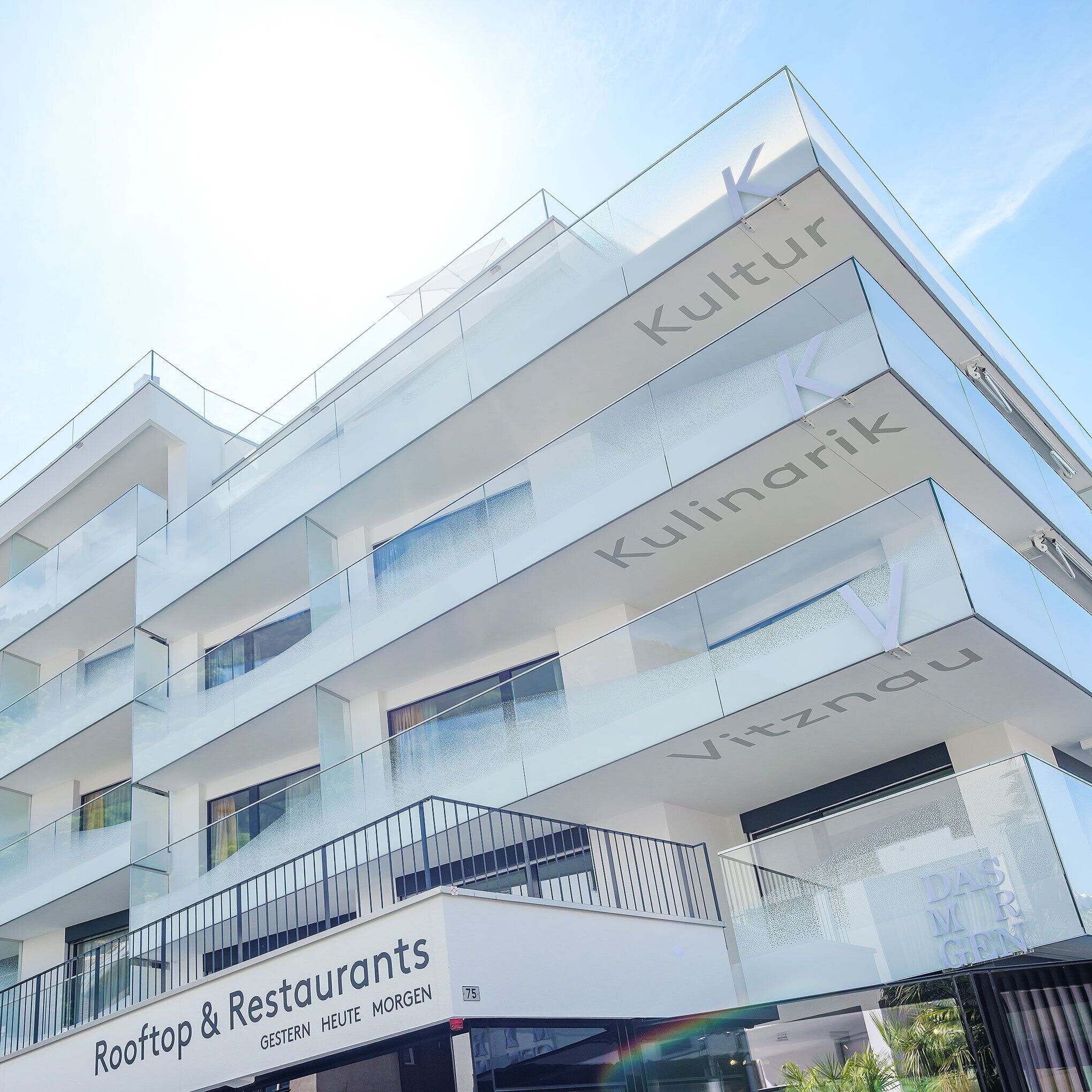 Un bâtiment moderne doté de nombreux balcons et d’une enseigne indiquant « Rooftop & Restaurants ».