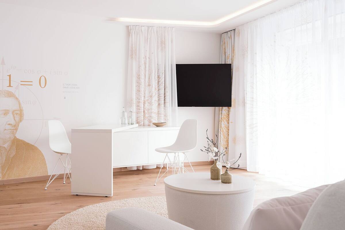 A modern living room with a white desk, a flat-screen TV, and a large wall mural.