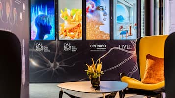 A modern interior with a seating area, a table, and a wall displaying various images.