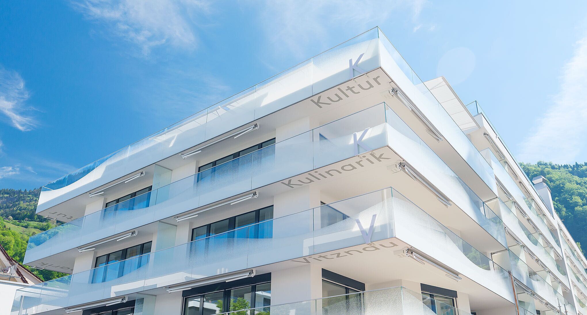 Un hotel de varios pisos con un diseño arquitectónico moderno, que cuenta con balcones y grandes ventanales.
