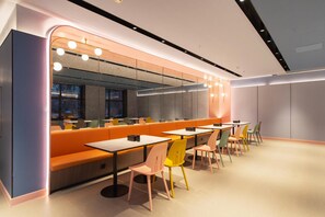 A modern restaurant with booths, tables, and chairs.
