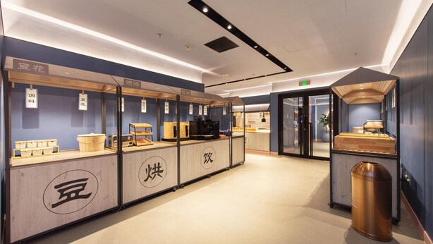 A modern interior with a reception desk, vending machines, and a trash bin. - Hanting Hotel (Fuxin)