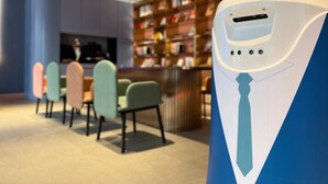 A modern interior with a seating area, bookshelves, and a unique white and blue object. - Hanting Hotel (Fuxin)