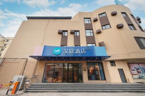 A hotel with a modern facade, a prominent sign, and a staircase leading to the entrance.