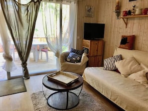 A cozy living room with a sofa, armchair, and a small round table with a tray. - Welcoming apartment with terrace A0314 (Cap-Ferret)